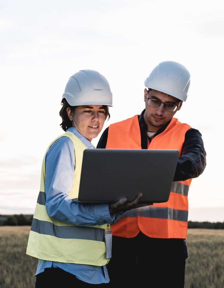 Renewable clean energy - Engineer people working with tablet at wind farm station - Soft focus on woman face