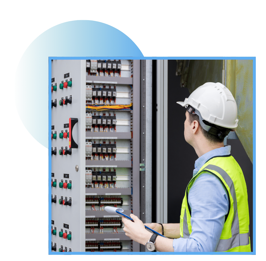 Technician in a hard hat inspecting a wind energy electrical panel