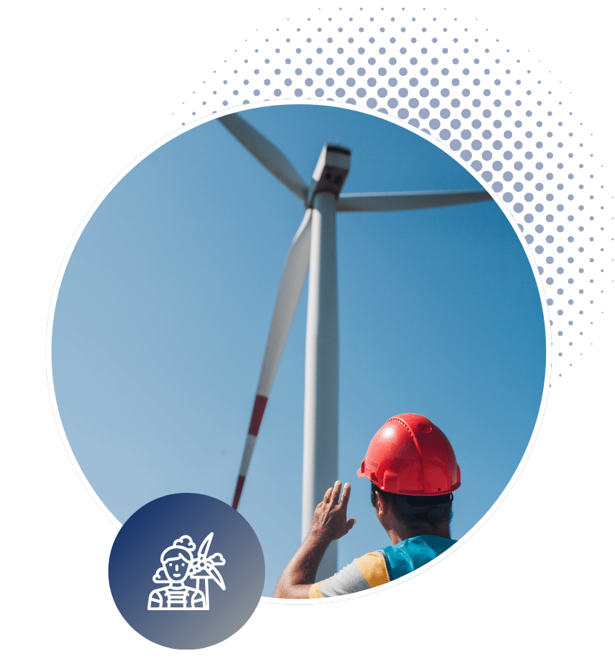 Wind Energy technician wearing a hard hat while looking up at a wind turbine.